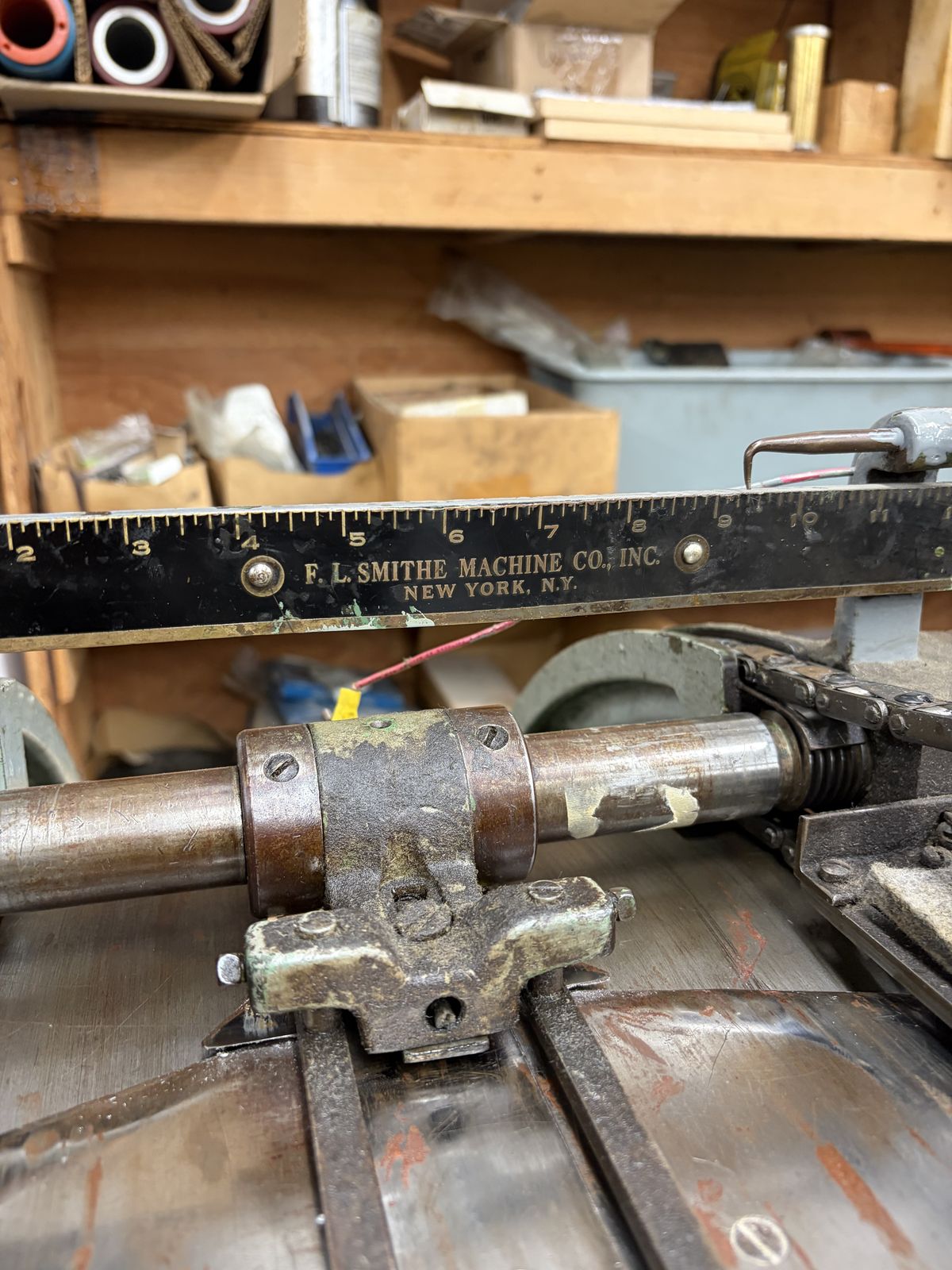 A steel feed gauge engraved F.L. Smithe Machine Co. Inc. New York, mounted on an envelope machine.
